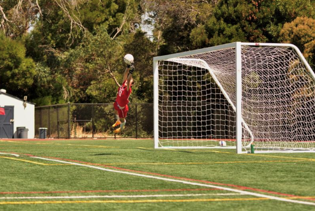 Goalie making a save in front of soccer goal