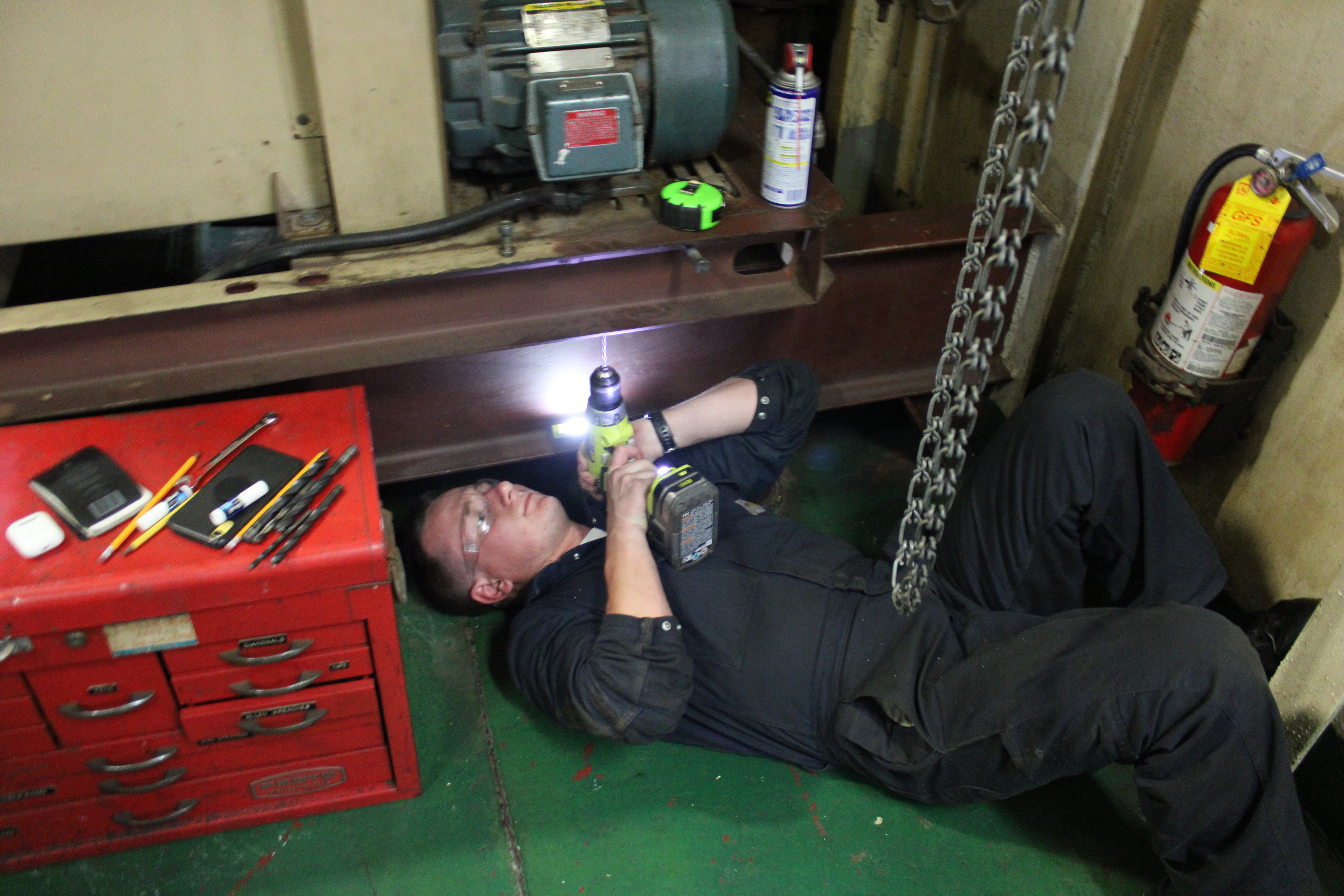 Featured in the photo below is Cadet Charlie Bedford (3/C) as he drills new holes for more tool mounting brackets. 